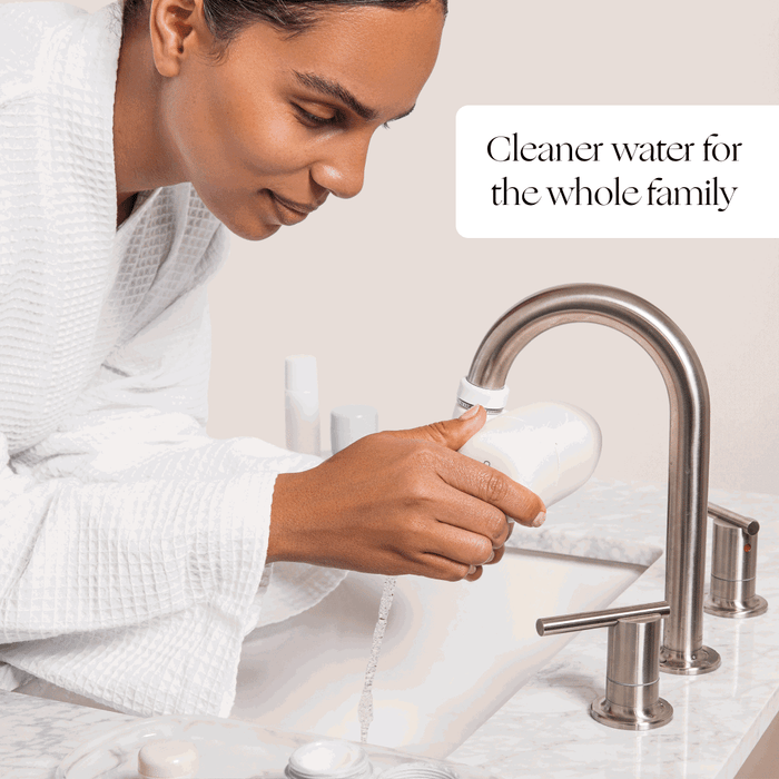 Faucet Filter | Lifestyle, Person in white robe installing Faucet Filter for clean water purification at bathroom sink - Canopy