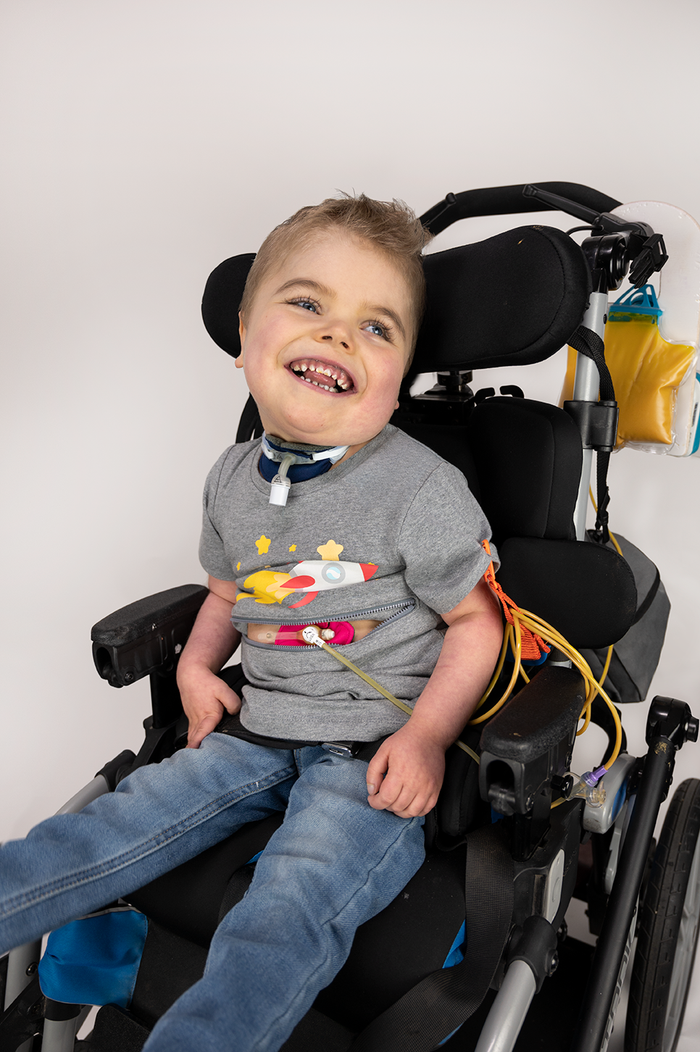 Boy in wheelchair wearing pink G-Tube Pad