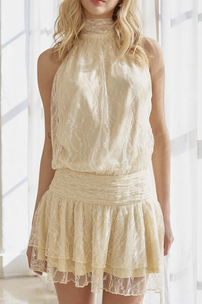 Woman wearing a beige lace dress in a bright room