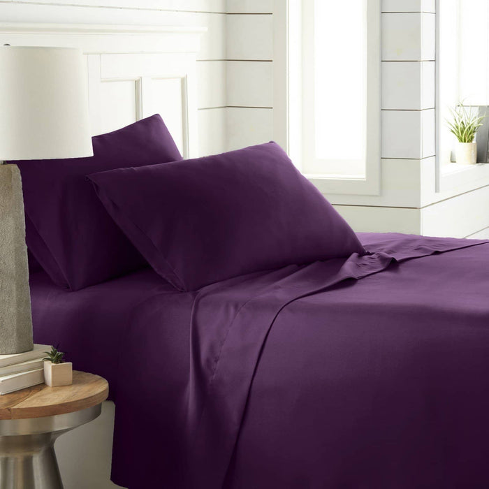 Angled view of Southshore Essentials 4-piece sheet set showcasing ultra-soft purple fitted sheet and two pillowcases on a made bed in a bright bedroom