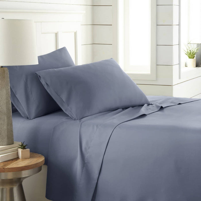 Angled view of Southshore Essentials 4-piece sheet set in steel blue on bed with two pillowcases and white headboard