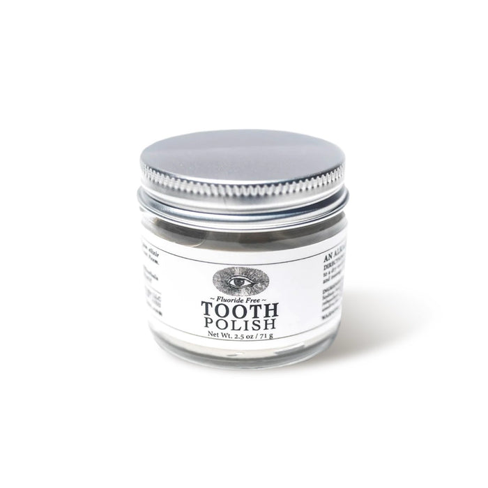 A small clear glass jar of Anima Mundi TOOTH POLISH, Fluoride Free, Net Wt. 2.5 oz / 71 g, with a silver lid on a white background, featuring a plant-based clay formula for naturally brighter smiles.